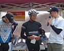 (Click for larger image) Brent Miller (l) and Dylan Cooper chat with commentator Ben Battisson at the prizegiving. Winner Peter Hatton had to leave early to ride that afternoon's road races.