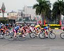 (Click for larger image) Points leader Kam Po Wong (orange jersey) leads the field around a corner with teammate and race leader  Kin San Wu (yellow jersey) in third