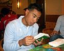 (Click for larger image) Daniel Lee studies his English slang while Derek Wong looks on.