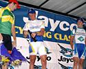 (Click for larger image) Runner-up Hilton Clarke (Portfolio Partners) gives winner Greg Henderson (Drapac-Porsche Cycling Team) a hand with the champers whilst third place-getter Simon Gerrans (Pitcher Partners) looks on