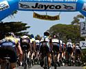 (Click for larger image) The field in the women's race makes its way underneath the Jayco banner in Portarlington