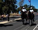 (Click for larger image) Victorian police patrol the streets of Portarlington on horse-back as the leaders speed by