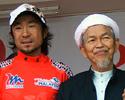 (Click for larger image) Race leader Makoto Iijima and stage winner Anuar Manan congratulated by local authorities